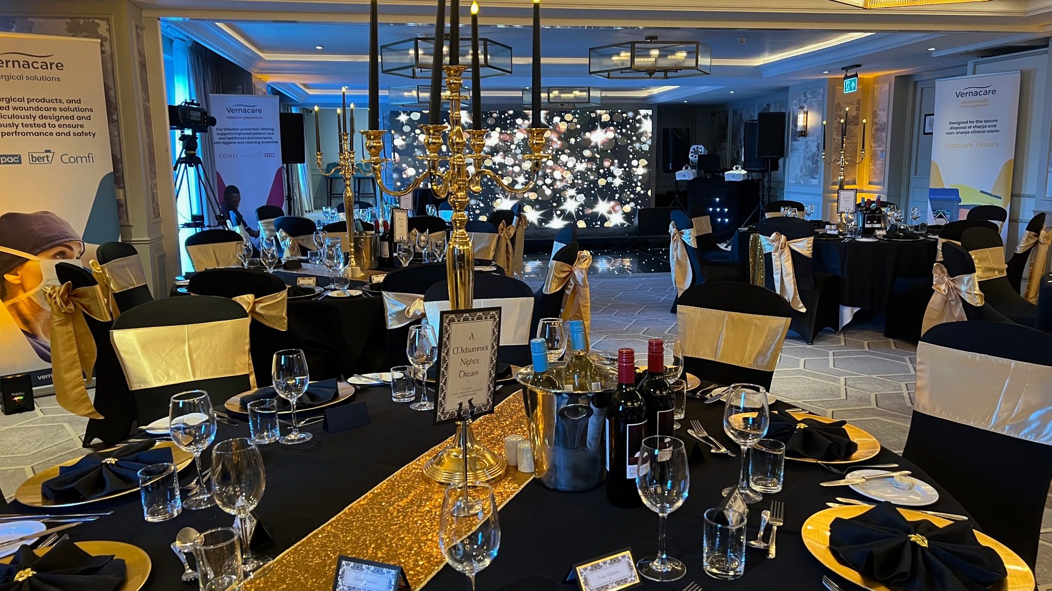 Wide view of gala dinner room, tables and stage